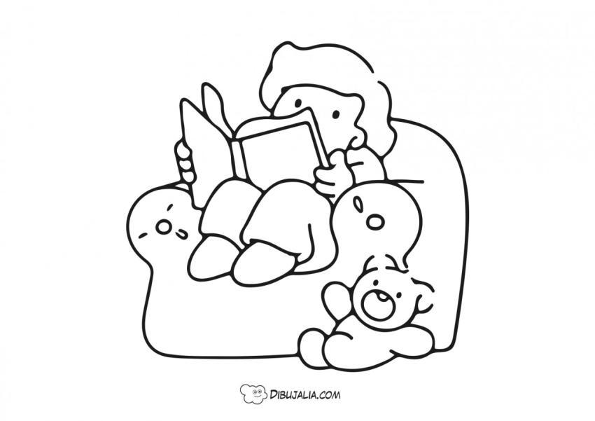 NIño lee en el sofa